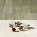 Set of four botanical brass-tone floral napkin rings