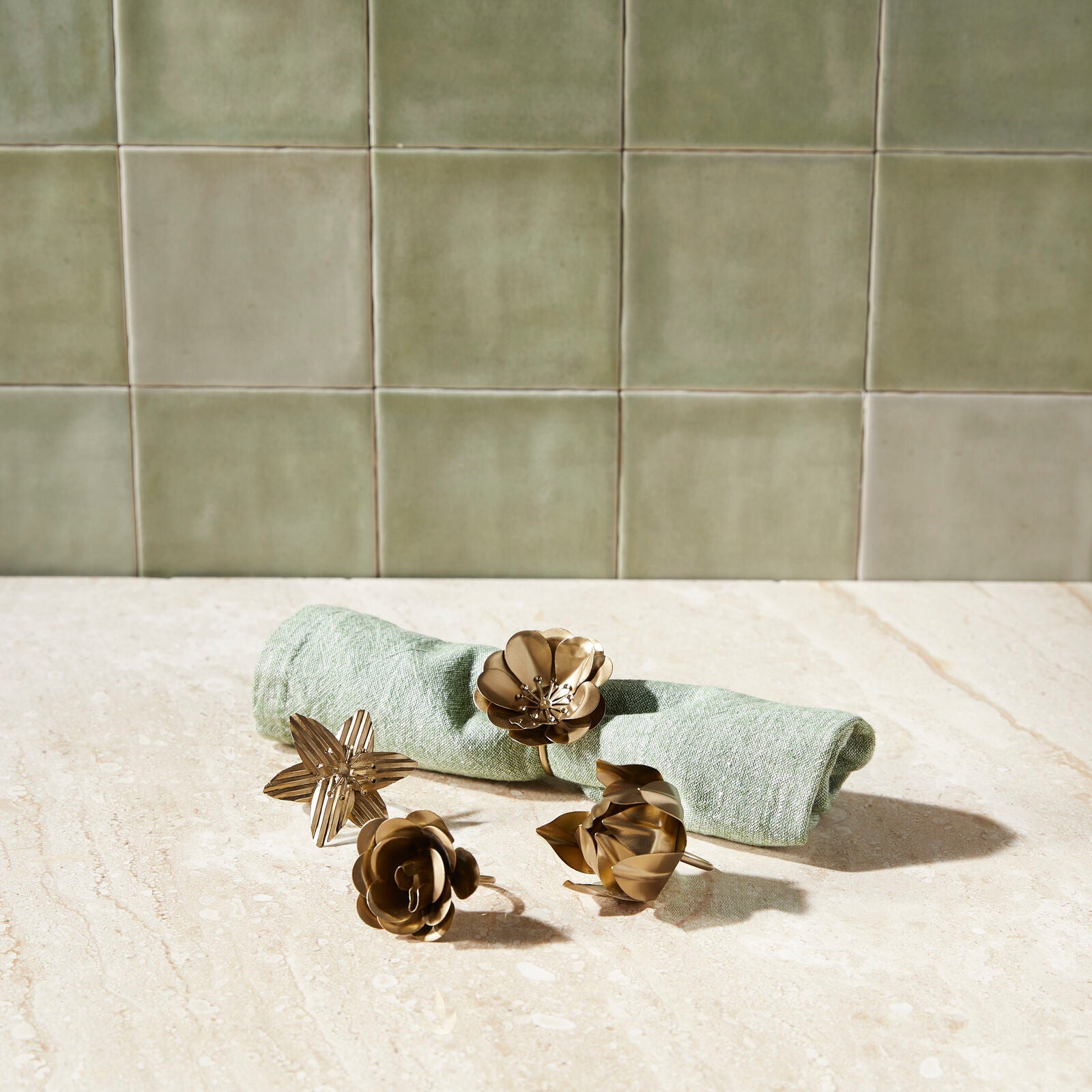 Set of four botanical brass-tone floral napkin rings