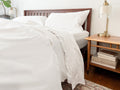 White organic cotton percale sheet set on a made bed